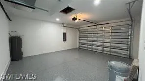 Spacious garage featuring a durable epoxy floor, an automatic overhead door, and recessed lighting