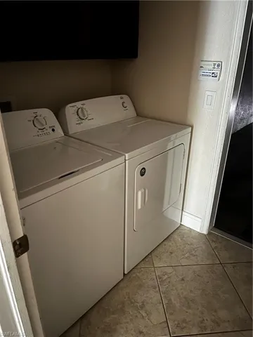 Dedicated laundry area featuring a white top-load washing machine and a white front-load dryer