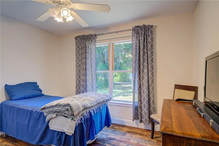 Bedroom with baseboards, a ceiling fan, and wood finished floors