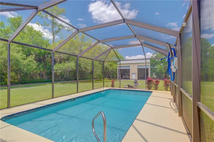 Outdoor pool with glass enclosure and a lawn