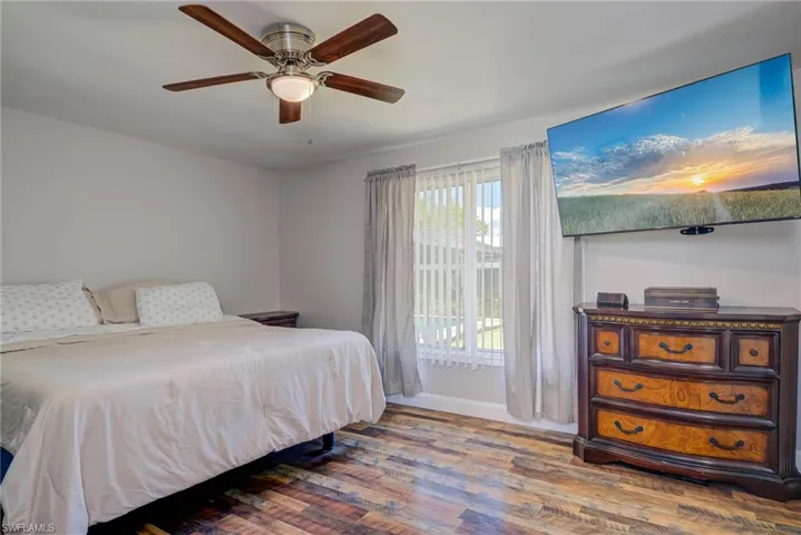 Bedroom featuring baseboards, a ceiling fan, and wood finished floors