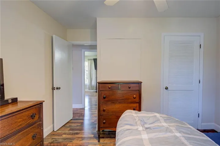 Bedroom with ceiling fan, baseboards, and dark wood finished floors