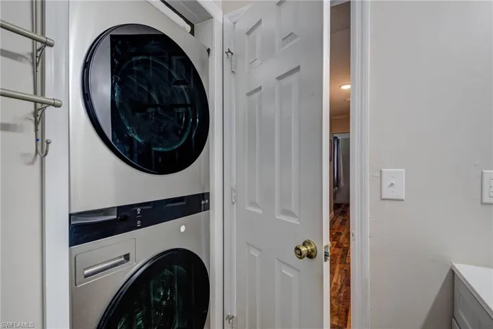Washroom with stacked washing maching and dryer and laundry area