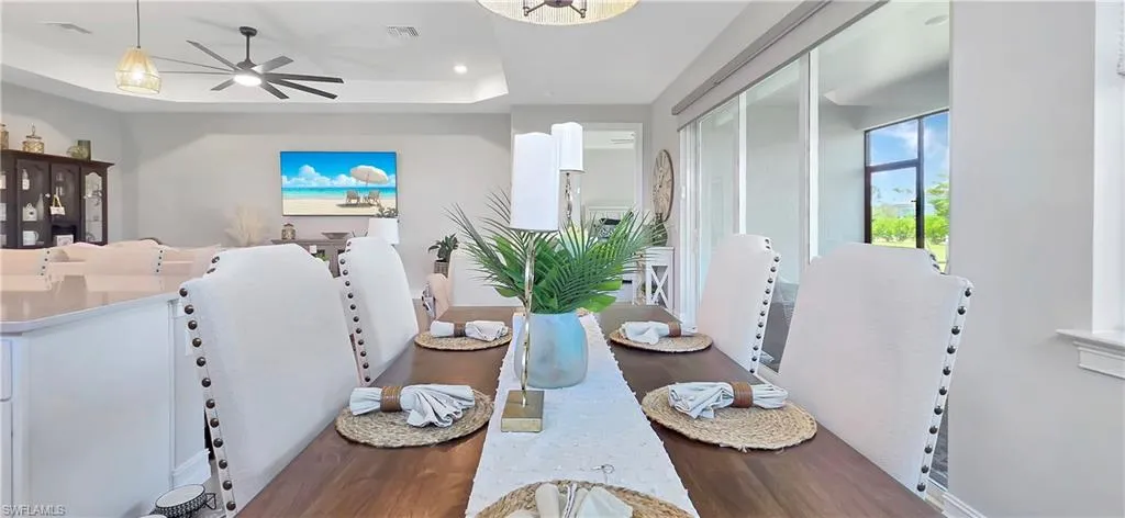 Expansive kitchen and dining area featuring light wood-finish flooring, recessed lighting, and a tray ceiling