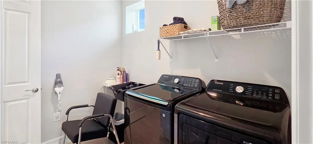 Dedicated laundry area featuring a white wire shelf, light gray wall paint, and a window for natural illumination