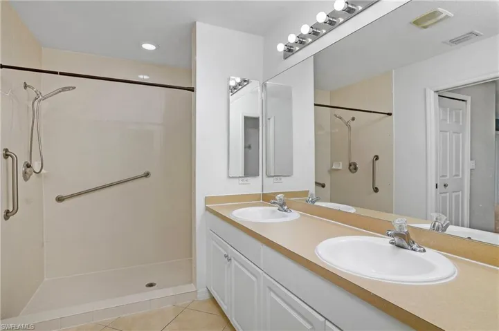 Bathroom featuring  double sink vanity, and a large walk-in shower