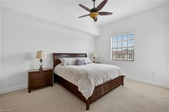 Bedroom with light carpet and a ceiling fan