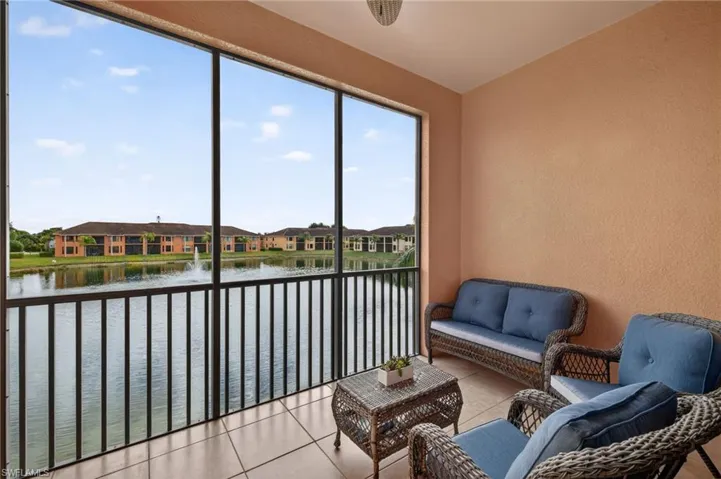 Sunroom / solarium featuring a water view, a residential view, and vaulted ceiling