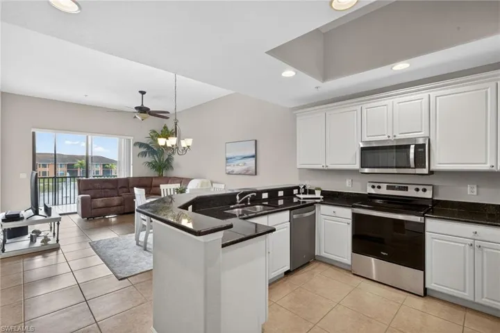 Kitchen featuring stainless steel appliances, a peninsula, white cabinetry, and open floor plan
