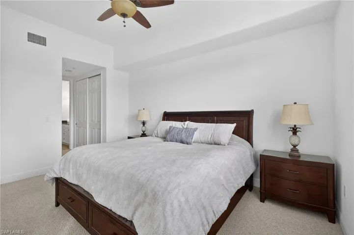 Bedroom with light carpet, a closet, and ceiling fan