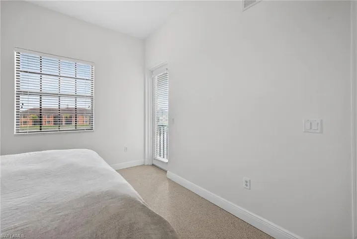 Bedroom with access to exterior and light carpet