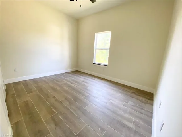 Unfurnished room featuring hardwood / wood-style flooring and ceiling fan