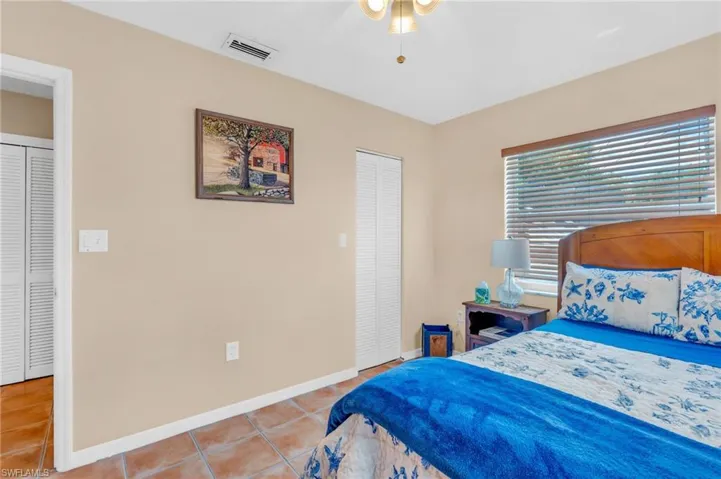 Tiled bedroom featuring a closet