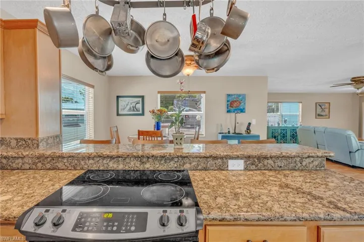Kitchen with a healthy amount of sunlight, light brown cabinets, and ceiling fan