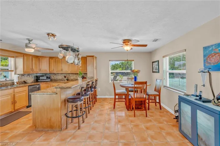 Kitchen with a healthy amount of sunlight, light stone countertops, and ceiling fan