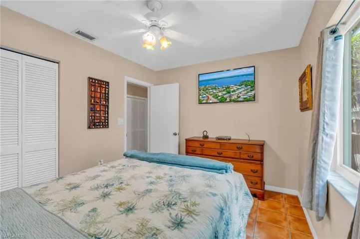 Bedroom with light tile patterned flooring and ceiling fan