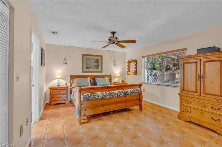Bedroom with ceiling fan and light tile patterned floors