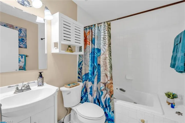 Full bathroom featuring shower / bathtub combination with curtain, vanity, and toilet
