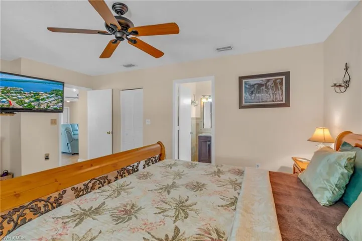 Bedroom with ceiling fan, a closet, and ensuite bath