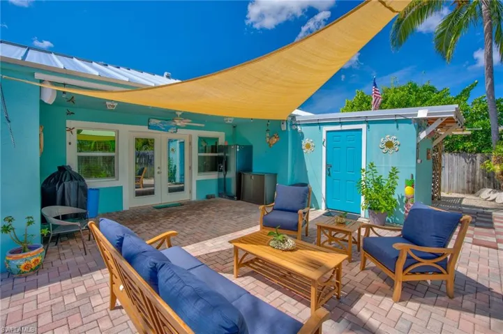 View of patio featuring outdoor lounge area, ceiling fan, french doors, and an outdoor structure