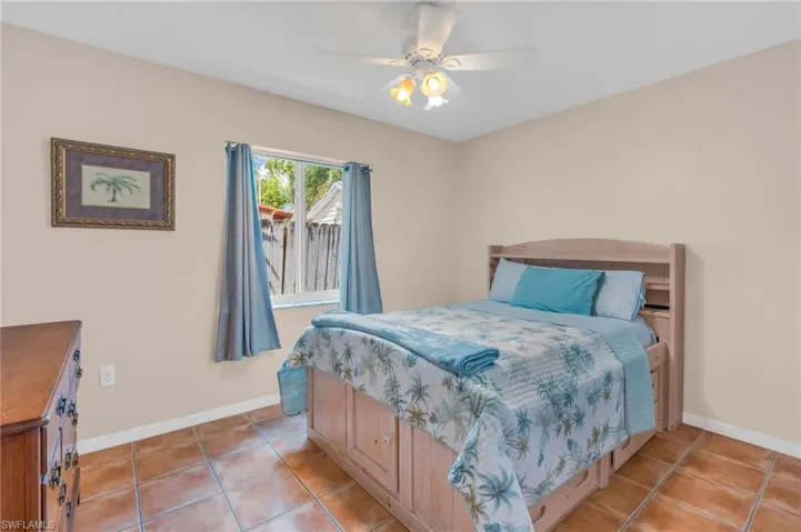Tiled bedroom featuring ceiling fan