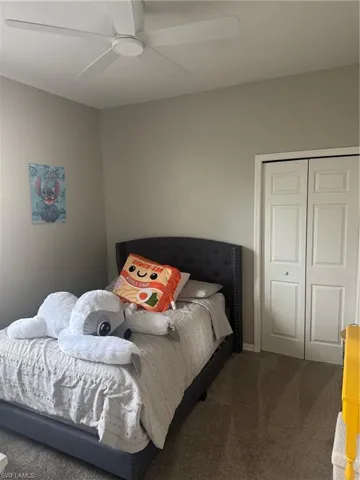 Bedroom featuring carpet floors, a closet, and ceiling fan