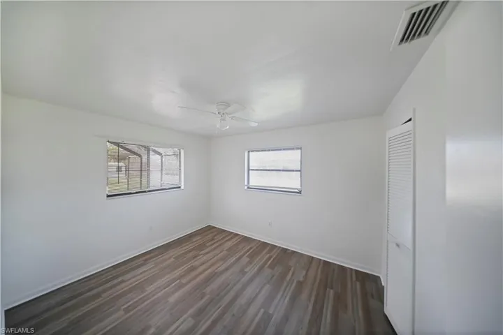 Bright interior space featuring wood-finish flooring, white walls, and a ceiling fan