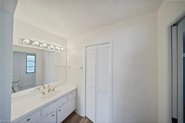 Bathroom vanity with an integrated sink, brushed nickel faucet, and a large mirror with a six-light fixture