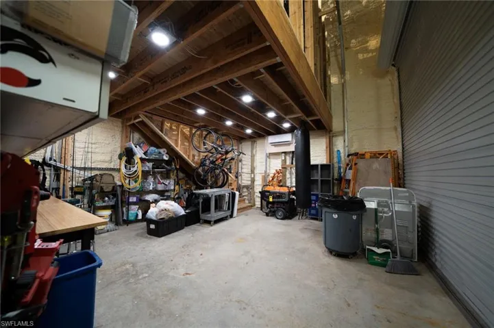 Misc room with an AC wall unit and unfinished concrete floors