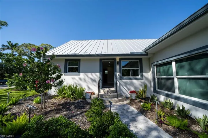 View of exterior entry with a standing seam roof, metal roof, and stucco siding