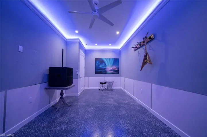 Home theater with recessed lighting, ornamental molding, ceiling fan, baseboards, and speckled floor