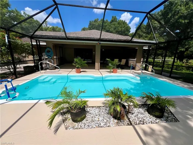 View of pool featuring a patio area and glass enclosure
