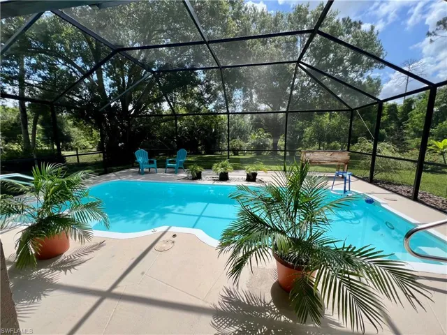 View of pool with a patio and glass enclosure