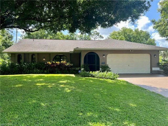 Ranch-style house featuring a garage and a front lawn