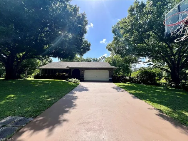 View of front of property with a front yard and a garage