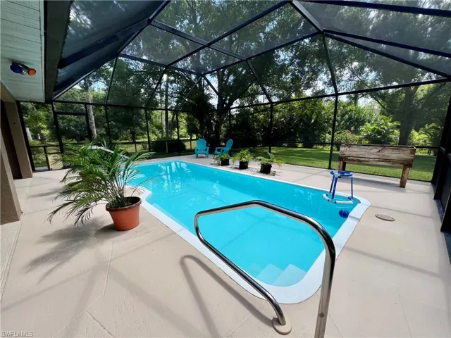 View of swimming pool featuring a patio area and a lanai