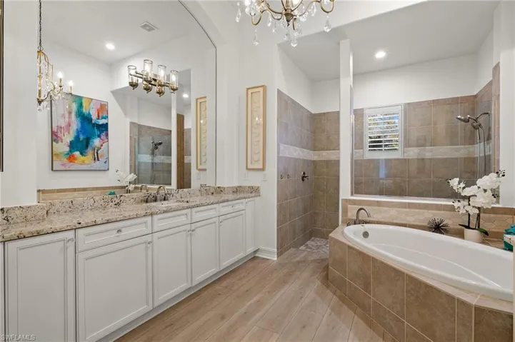 Bathroom featuring vanity, shower with separate bathtub, and hardwood / wood-style flooring
