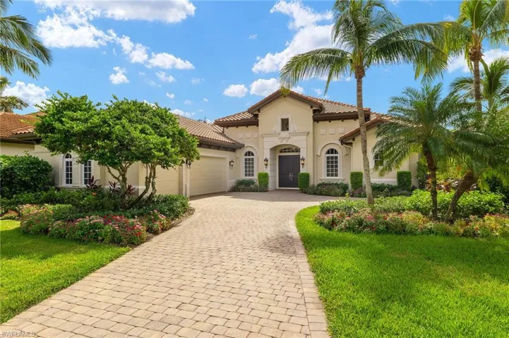 Mediterranean / spanish-style home featuring a front yard and a garage