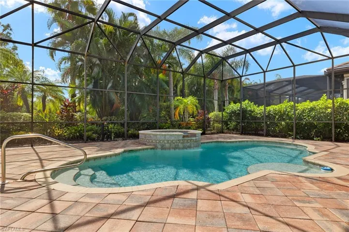 View of pool featuring a patio, an in ground hot tub, and glass enclosure
