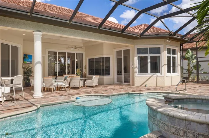 View of swimming pool featuring an in ground hot tub, ceiling fan, a patio, and a lanai