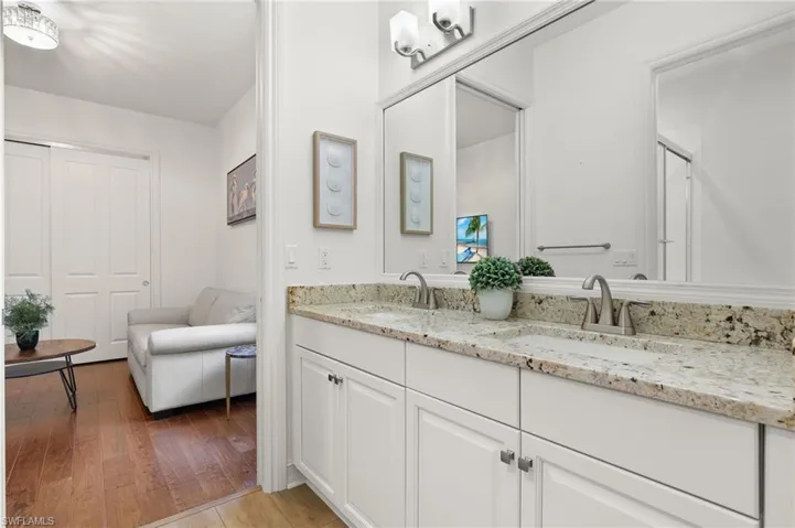 Bathroom with vanity, hardwood / wood-style floors, and a shower with shower door