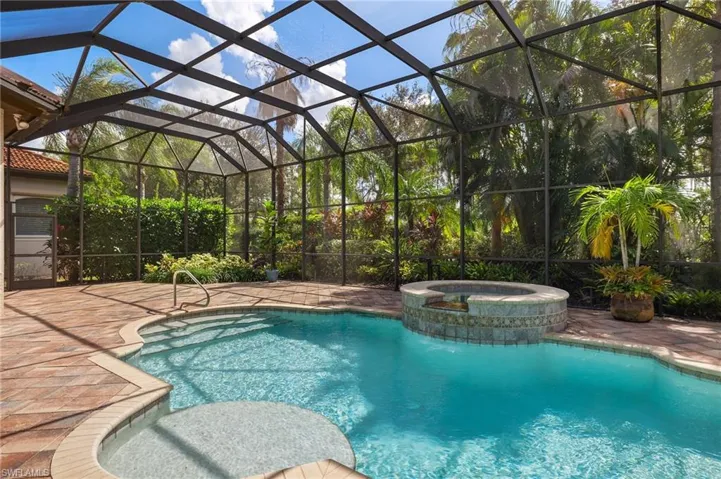 View of swimming pool featuring an in ground hot tub and a lanai