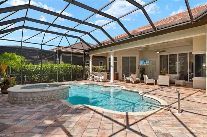 View of swimming pool with a patio area, a lanai, an in ground hot tub, and ceiling fan