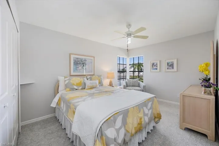 Bedroom with a closet, ceiling fan, and carpet flooring