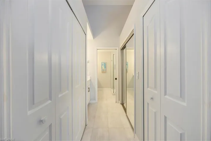 Corridor featuring light tile patterned floors and baseboards