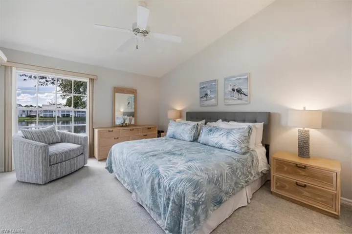 Carpeted bedroom featuring lofted ceiling and ceiling fan