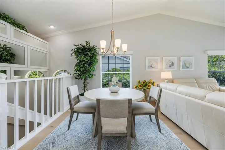 Dining area with ornamental molding, wood finished floors, suspended lighting, and healthy amount of natural light