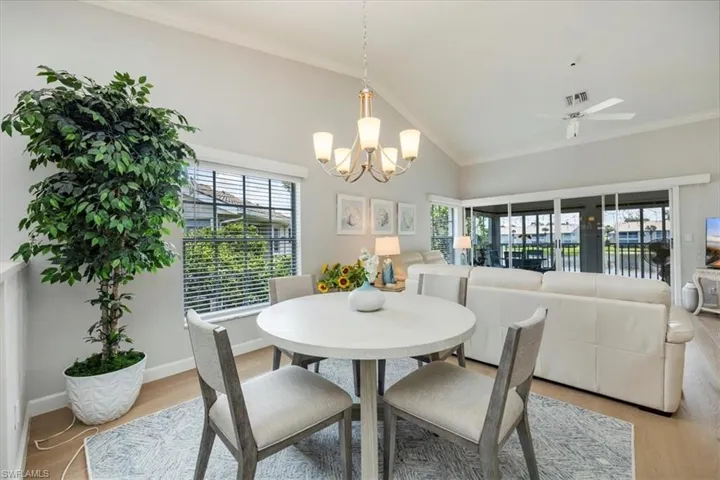 Dining room featuring vaulted ceiling, crown molding, a ceiling fan, light wood finished floors, and healthy amount of natural light