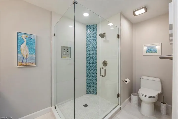 Bathroom with a stall shower, recessed lighting, and light tile patterned floors