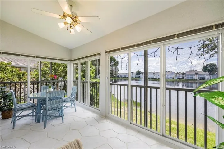 Sunroom featuring a water view and lofted ceiling